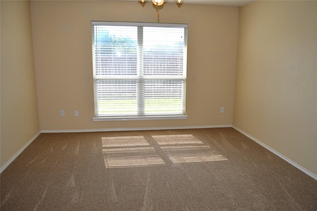 carpeted spare room with baseboards and ceiling fan