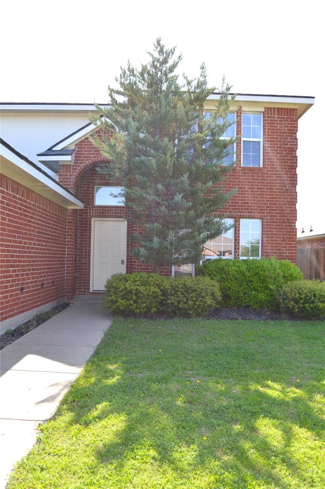 view of front of property with brick siding and a front lawn