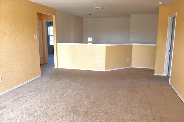 carpeted empty room featuring baseboards and visible vents