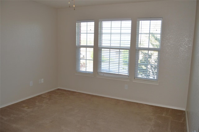 spare room with carpet, baseboards, and ceiling fan