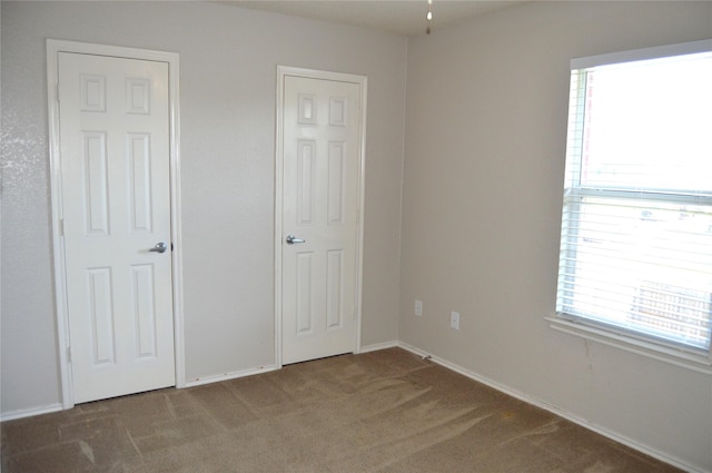 unfurnished bedroom featuring carpet floors and baseboards