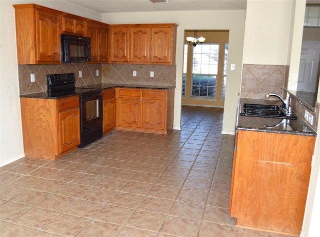 kitchen featuring decorative backsplash, a sink, brown cabinetry, and black appliances