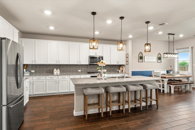 kitchen featuring appliances with stainless steel finishes, white cabinetry, dark wood finished floors, and a sink