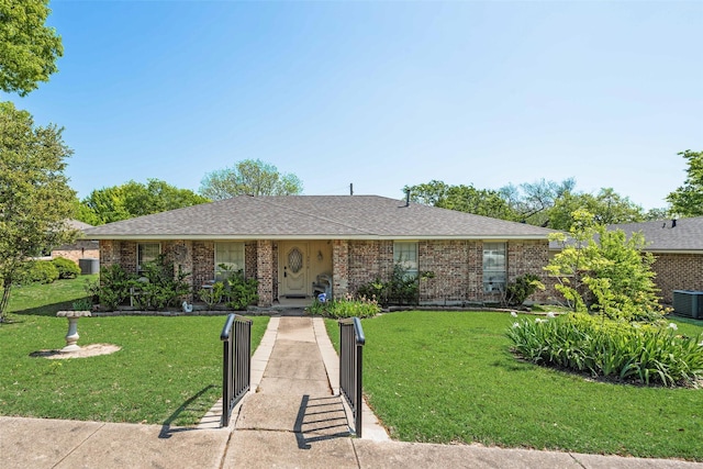 ranch-style home featuring brick siding, a front yard, and central AC unit