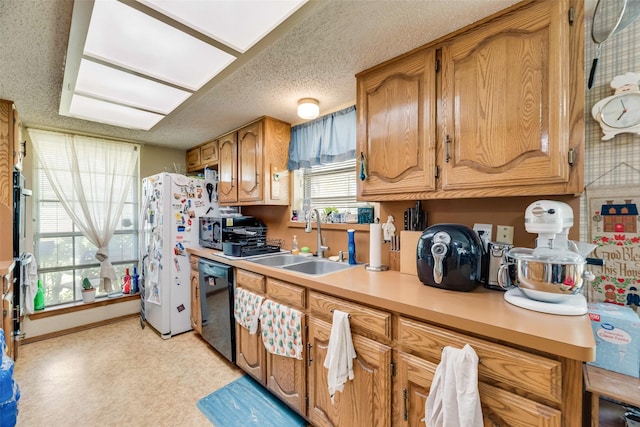 kitchen featuring a sink, brown cabinets, oven, light countertops, and black dishwasher