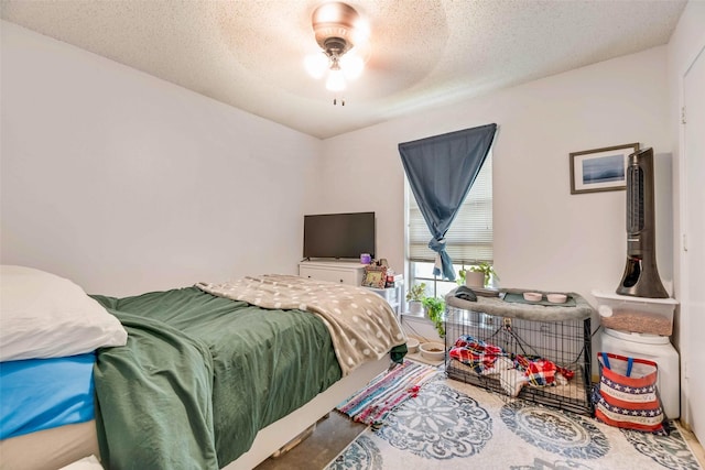 bedroom with a ceiling fan and a textured ceiling