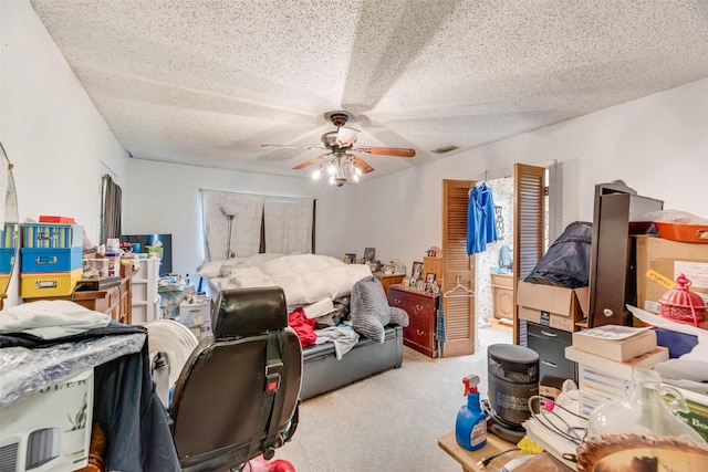 bedroom featuring carpet floors, a textured ceiling, and a ceiling fan