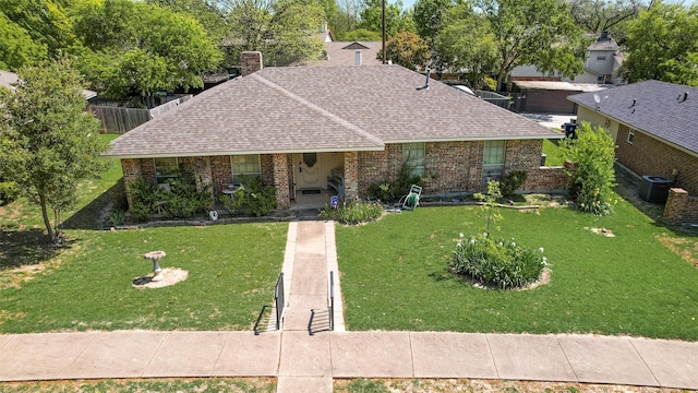 ranch-style house with brick siding, roof with shingles, a front yard, and covered porch