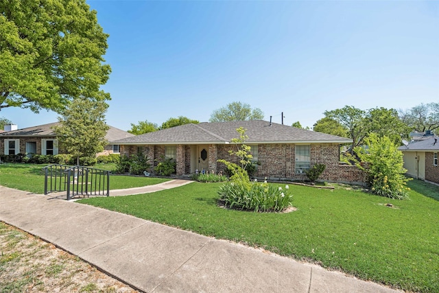 single story home with brick siding and a front yard