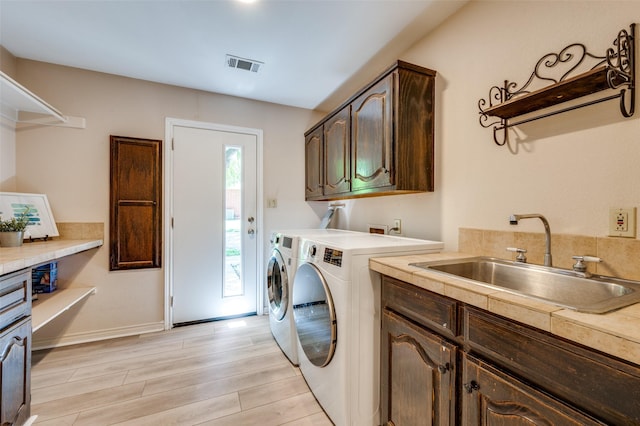 300 Dove Crk, Mckinney, TX 75071 - clothes washing area featuring visible vents, washing machine and dryer, light wood-style floors, a sink, and cabinet space