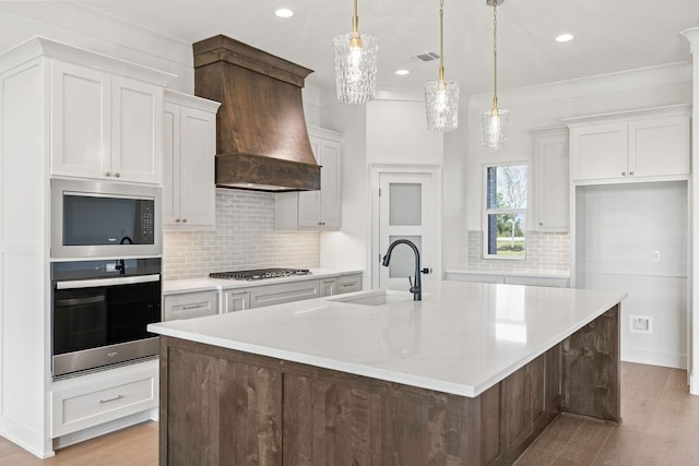 737 Burr Oak Ln, Weatherford, TX 76085 - kitchen with a sink, decorative backsplash, a large island with sink, stainless steel appliances, and premium range hood