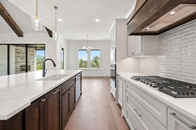 737 Burr Oak Ln, Weatherford, TX 76085 - kitchen featuring plenty of natural light, wall chimney range hood, a sink, decorative backsplash, and appliances with stainless steel finishes