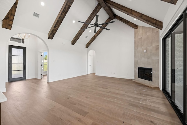 737 Burr Oak Ln, Weatherford, TX 76085 - unfurnished living room featuring arched walkways, visible vents, beamed ceiling, a ceiling fan, and high vaulted ceiling