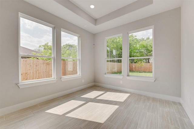 empty room featuring baseboards, recessed lighting, and a tray ceiling