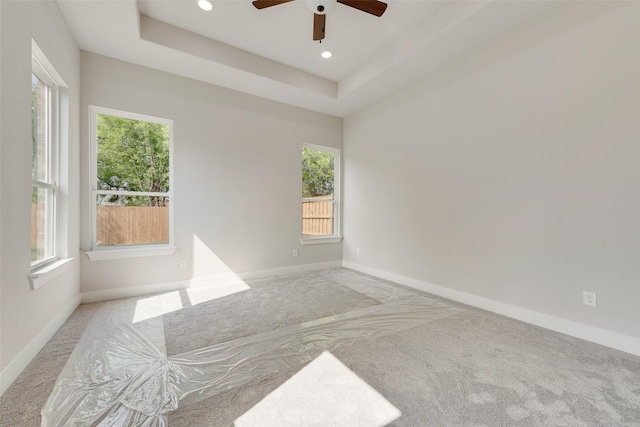 empty room featuring carpet floors, a ceiling fan, and a healthy amount of sunlight