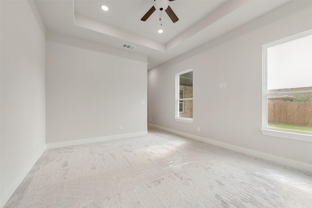 spare room featuring ceiling fan, visible vents, a raised ceiling, carpet flooring, and recessed lighting
