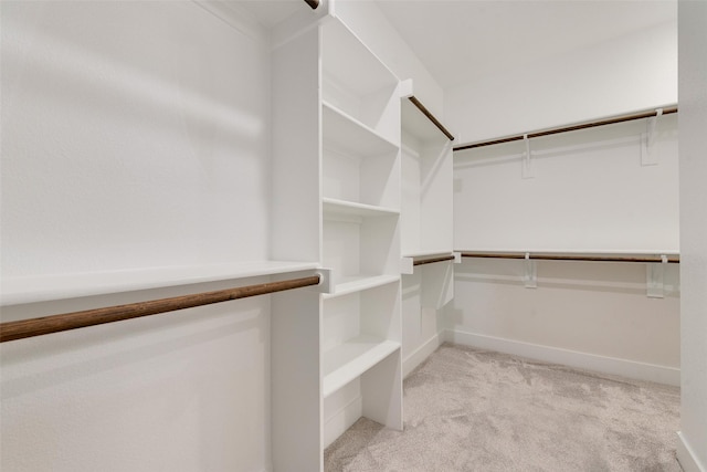 walk in closet featuring light carpet
