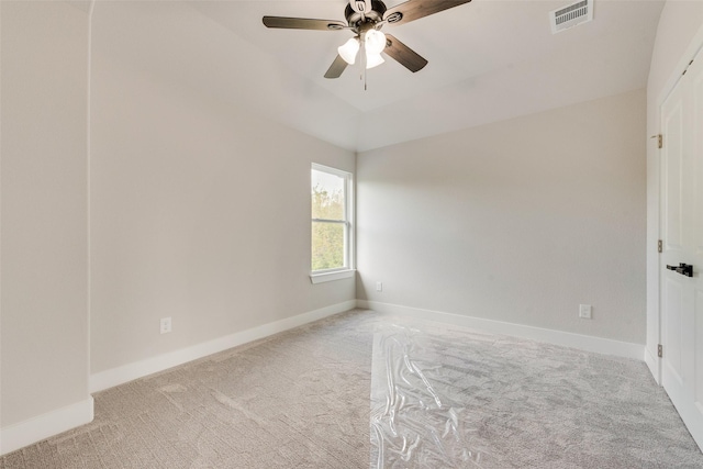 carpeted spare room featuring visible vents, baseboards, and ceiling fan