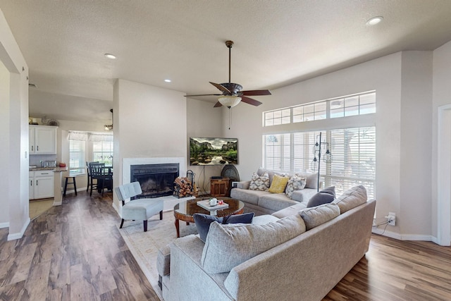 231 Dove Hill Ln, Weatherford, TX 76088 - living room featuring baseboards, recessed lighting, a fireplace with raised hearth, wood finished floors, and ceiling fan
