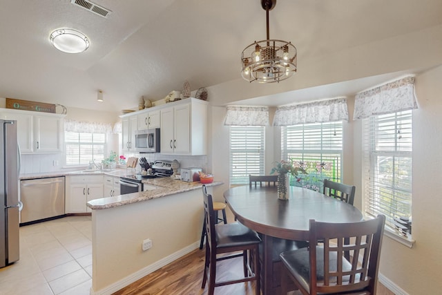 231 Dove Hill Ln, Weatherford, TX 76088 - kitchen with white cabinets, visible vents, stainless steel appliances, and an inviting chandelier