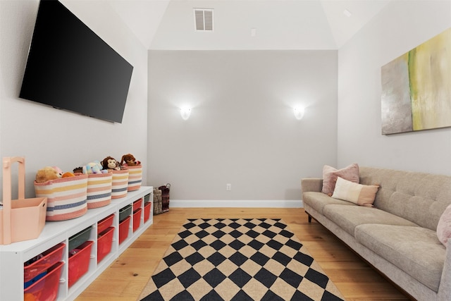 recreation room with baseboards, visible vents, light wood finished floors, and high vaulted ceiling