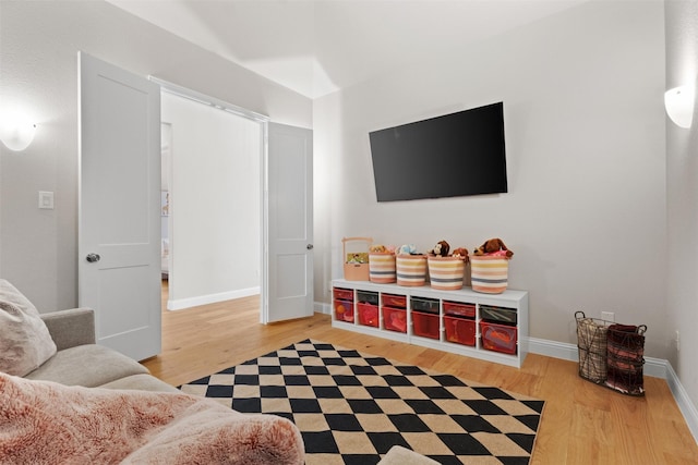 living area featuring baseboards and light wood finished floors