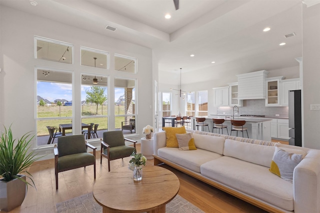 living room featuring plenty of natural light, a ceiling fan, wood finished floors, and recessed lighting