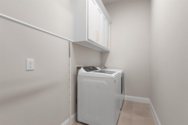 washroom with cabinet space, light tile patterned flooring, baseboards, and washer and dryer