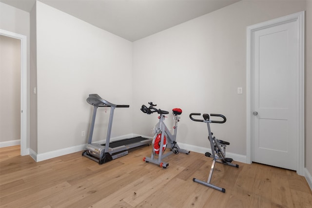 exercise room featuring baseboards and wood finished floors