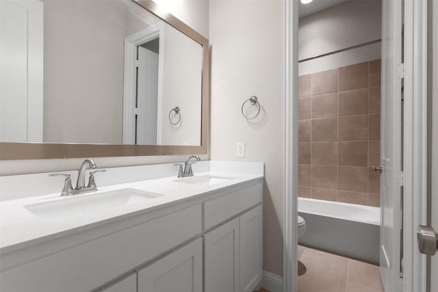 bathroom featuring double vanity, toilet, shower / bathtub combination, and a sink