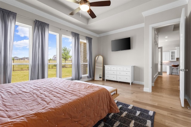 bedroom featuring a tray ceiling, baseboards, light wood-style floors, access to outside, and ornamental molding