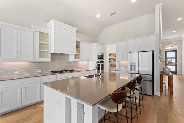 kitchen with decorative backsplash, stainless steel appliances, visible vents, and a sink