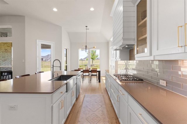 kitchen featuring recessed lighting, light wood-style flooring, decorative backsplash, and a sink
