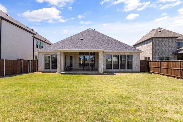 rear view of property with a patio area, a fenced backyard, and brick siding
