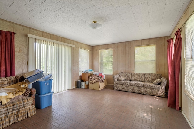 living area with wooden walls and brick patterned floor
