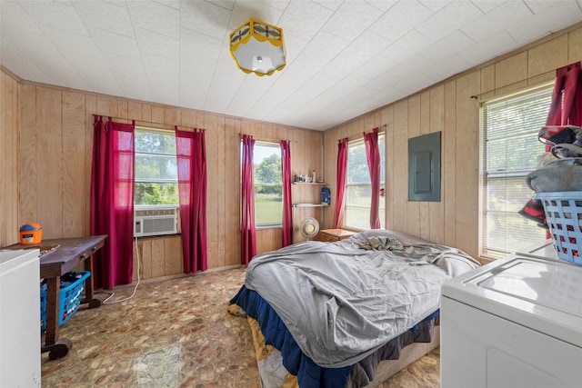 bedroom with washer / dryer, wooden walls, electric panel, and cooling unit