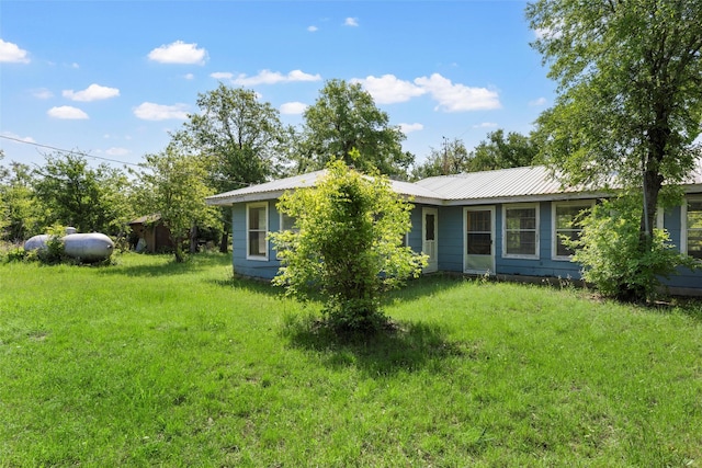 exterior space featuring a front lawn and metal roof