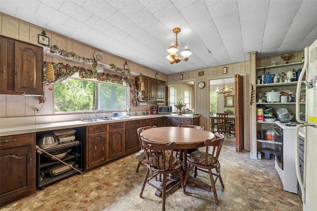 kitchen featuring a chandelier, light countertops, and wood walls