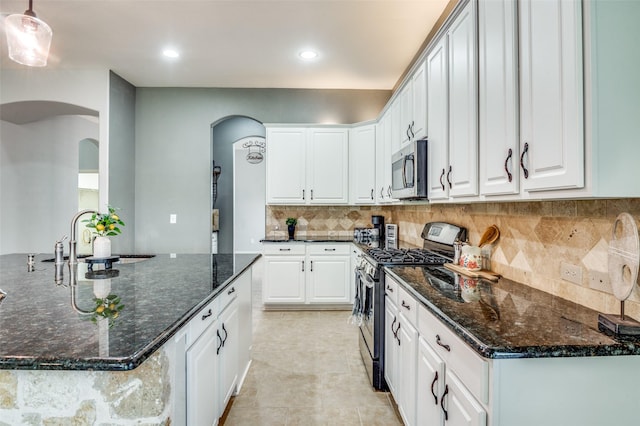 5220 Grove Cove Dr, Mckinney, TX 75071 - kitchen featuring arched walkways, white cabinetry, stainless steel appliances, and a sink