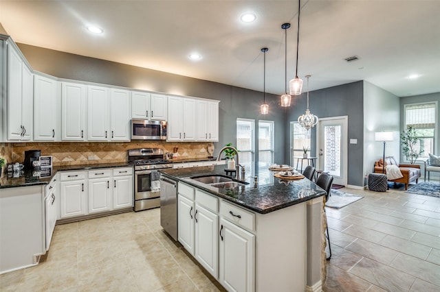 5220 Grove Cove Dr, Mckinney, TX 75071 - kitchen with stainless steel appliances, visible vents, light tile patterned floors, a sink, and decorative backsplash