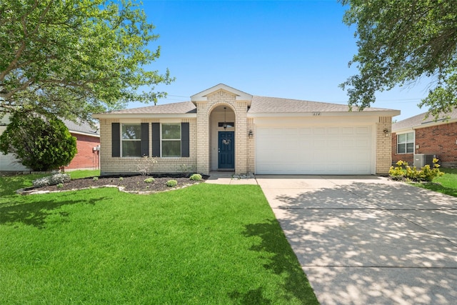 ranch-style home featuring roof with shingles, driveway, a garage, brick siding, and a front yard