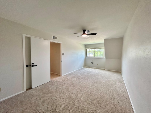 spare room with visible vents, light carpet, baseboards, and ceiling fan