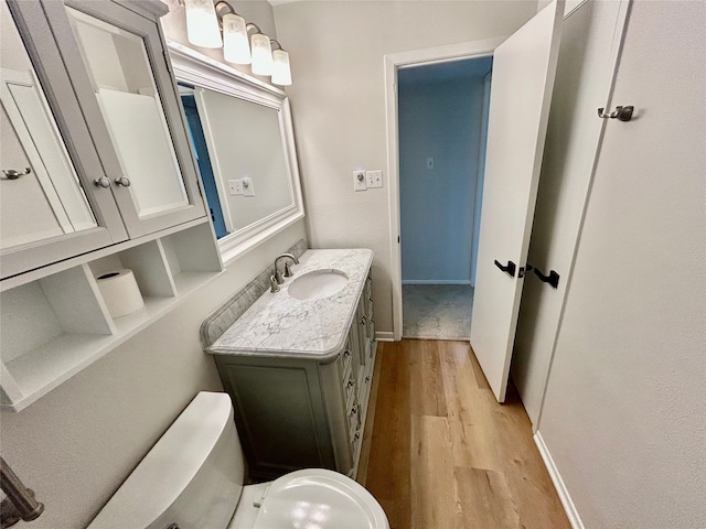 bathroom featuring baseboards, vanity, and wood finished floors
