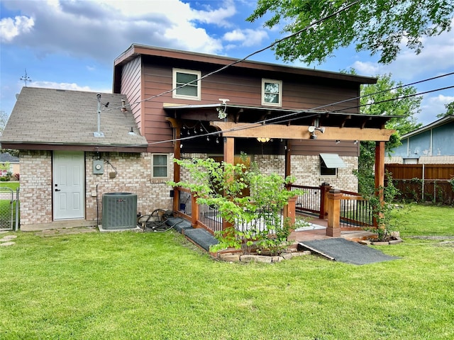 back of property featuring fence, a lawn, brick siding, and cooling unit