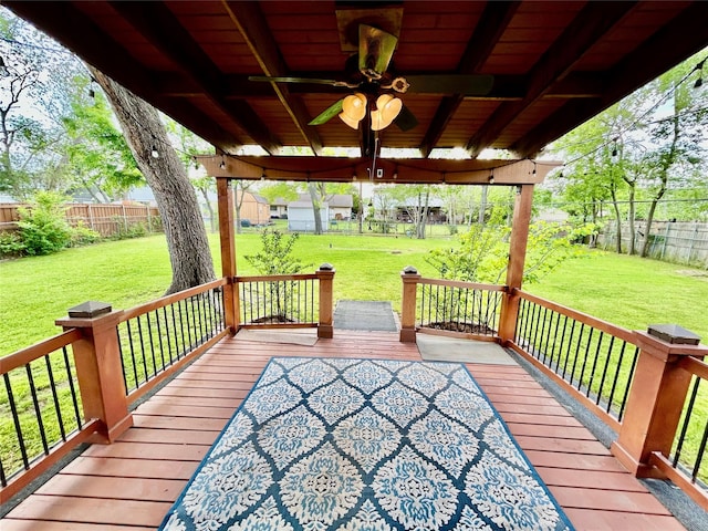deck with a lawn, ceiling fan, and a fenced backyard