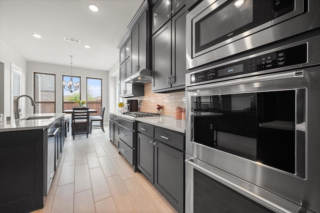 9300 Pecan Woods Trl, Argyle, TX 76226 - kitchen with appliances with stainless steel finishes, recessed lighting, tasteful backsplash, a sink, and light countertops