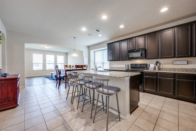 3412 San Lucas Ln, Denton, TX 76208 - kitchen featuring black appliances, a breakfast bar, plenty of natural light, an island with sink, and recessed lighting