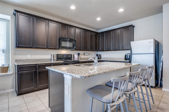 3412 San Lucas Ln, Denton, TX 76208 - kitchen featuring black appliances, light tile patterned floors, dark brown cabinetry, baseboards, and recessed lighting
