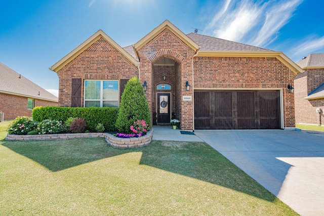 single story home featuring a front lawn, roof with shingles, driveway, brick siding, and a garage