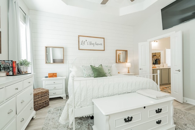 bedroom with light wood-type flooring, wood walls, and a ceiling fan